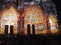 Timpano della Cattedrale di Amiens illuminato con luce colorata per suggerire il suo aspetto originario