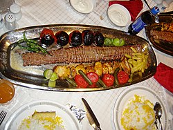 Chello (Čelo) kabab (kebab s rýží), perské národní jídlo. Žluté kusy masa jsou grilované kuře.