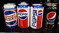 Latas mostradas de izquierda a derecha: logo de los 1940, logo de los 1980, logo de los 1990 y Pepsi 0, con el logo de 2014.