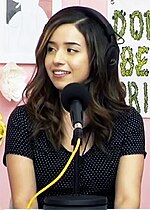 photograph of pokimane on a podcast wearing a hyperx headset