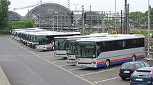 Barevná fotografie zobrazující v řadě parkující autobusy
