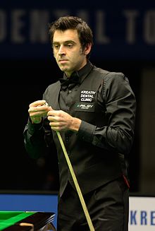 Ronnie O'Sullivan chalking a cue stick