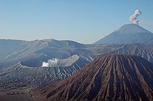 Meze maldekstre la vulkano Bromo. En la fono dekstre la plej alta monto de Javo, la vulkano Semeru. Malfone dekstre la Batok