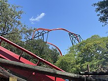 A view of Tigris's heartline roll among the trees with another roller coaster, SheiKra, in the foreground