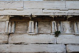 wall made from large marble blocks: ancient Greek letters are just about visible on some of them.