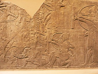 Assaut d'une ville avec des engins de siège, bas-relief du Palais Nord-Ouest de Nimroud (IXe siècle av. J.-C.). British Museum.