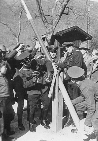 Photographie en noir et blanc d'hommes démantelant un poste-frontière