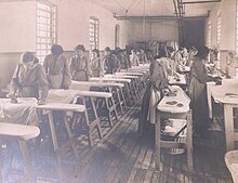 Inmates of the Indiana Industrial School for Girls ironing fabrics, circa 1907 Indiana Industrial School for Girls photograph album - DPLA - 4e79179cef5494e1e94524e5e09f5482 (page 17) (cropped).jpg