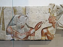 Horus offers life to the pharaoh, Ramesses II. Painted limestone. c. 1275 BC. 19th dynasty. From the small temple built by Ramses II in Abydos.Louvre museum, Paris, France. Le roi Ramses parmi les dieux (Louvre, B 13).jpg