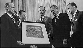 Jack N. James (center), JPL's Mariner 4 Project Manager, with a group in the White House presenting the spacecraft's famous picture Number 11 of Mars to US President Lyndon B. Johnson (center right) in July 1965 Pickering-Johnson.jpg