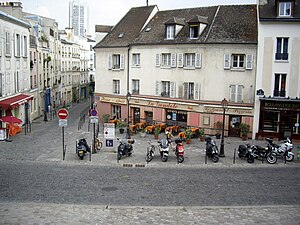 Place Saint-Blaise, Paris 20e. Vue de l'église Saint-Germain-de-Charonne. Au premier plan, le rue de Bagnolet. Au fond sur la gauche, la rue Saint-Blaise.