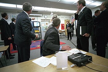 U.S. President George W. Bush talks on a STU-III secure telephone as he watches television coverage of the September 11 attacks from a school classroom in Florida. President George W. Bush watches Television Coverage of Terrorist Attacks.jpg