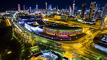 Kuwait City nightscape, with the Kuwait National Assembly visible (illuminated white building in center) Swr@ jwy@ lmbn~ mjls lm@.jpg