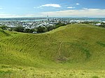 A Mount Eden vulkán krátere, háttérben a város központja