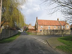 A rural village road with high walls and stone built houses