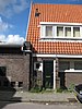 Blok met 8 keukenwoningen, zo genoemd vanwege destijds nieuwe plaatsing van keuken aan de voorzijde, aan de zijkant een houten topgevel, bouwstijl Amsterdamse School, samen met de poortgebouw langs de Purmerweg centraal deel van Tuindorp Nieuwendam