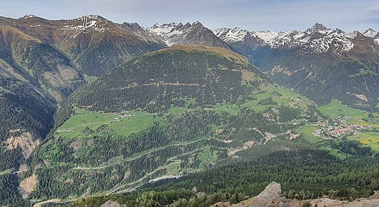 Blick nach Osten zum Cuolm da Latsch (2295 m), ein Rasenhügel an dessen Westhang die Dörfer Stugl/Stuls (links) und Latsch liegen, am rechten Bildrand ist Bergün/Bravuogn zu sehen