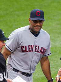 A man in a gray baseball uniform and navy cap