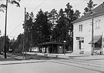 Smedslättstorgets spårvagnshållplats 1931 med kiosken. Till höger syns fröken Brolins café med skylten "Café" samt Bergmans färghandels skyltfönster.