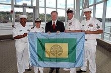 US Navy 070914-N-6362C-001 Roy Buol, mayor of the city of Dubuque, presents Sailors assigned to amphibious transport dock USS Dubuque (LPD 8) with a flag of the city.jpg