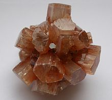 Aragonite is an orthorhombic polymorph of calcite. Aragonite redbrown crystals.jpg