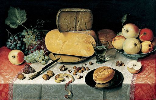Still life with fruits, nuts, & large wheels of cheese.