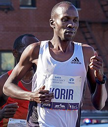 Black man with white top running.