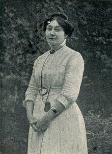 Photograph of Marie Dauguet, standing in a garden.