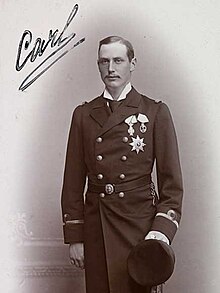 Old autographed black-and-white photograph of a young man in a military uniform with 3 large decorations on the left side of his chest and holding a military cap.