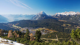 Blick vom Härmelekopf auf Seefeld. Im Hintergrund links das Inntal, in der Mitte das Mieminger Gebirge und rechts das Wettersteingebirge