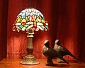 Tiffany dragonfly lamp with pigeon sculptures