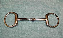 A metal horse bit with a jointed mouthpiece and a ring on either side