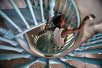 Un peintre en action dans une cage d'escalier, en Inde. (définition réelle 4 368 × 2 912)