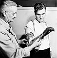 Ronny Jaques: Private Ed Gerris of the Royal Canadian Army Service Corps, with Principal Eccles of Shaw Business Schools, is using a specially-designed glove-covered artificial hand to learn penmanship during a retraining course on Primary Accountancy, 1944