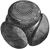 A black and white drawing of a complex structure resembling a sphere with several elaborately decorated part-spheres stuck to its surface. The decorations include sworls, circular shapes and wavy lines.