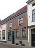 Rechts onderkelderd huis van parterre, verdieping en hoog zadeldak, evenwijdig aan de straat