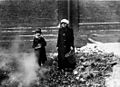 Child and adult collecting coal or coke