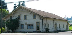 A large building with discolored siding and yellow window frames