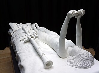 Figure on bed with Camera and Weapons (2013) Thom Puckey. Marmo statuario, ricavato da un unico blocco. Dimensioni: 206 x 104 x 77 cm
