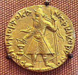 מטבע זהב של קנישקה. כיתוב יווני-באקטרי (אנ'): ϷΑΟΝΑΝΟϷΑΟ ΚΑΝΗϷΚΙ ΚΟϷΑΝΟ "שאונאנושאו קנישקי קושאנו" "מלך המלכים, קנישקה הקושאן" המוזיאון הבריטי