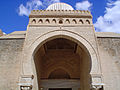 Gros plan sur la partie supérieure du porche de Bab al-Gharbi, ouvrant par un arc outrepassé brisé.