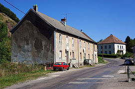 À gauche, un long bâtiment à deux étages (anciens bureaux), à droite un bâtiment plus trapu avec un toit à quatre pans (ancien bâtiment des machines) tous deux transformés en logements.