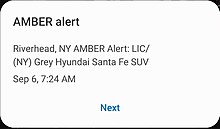 Желтое предупреждение на Android. Желтое предупреждение на Android. Заглавными буквами написано: «Риверхед, штат Нью-Йорк. Предупреждение AMBER: LIC / [номерной знак удален] (Нью-Йорк) Серый внедорожник Hyundai Santa Fe».