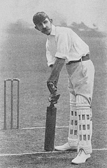 A black and white photo of a man holding a cricket bat