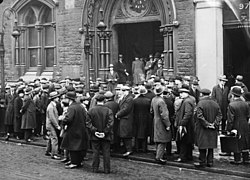 Unemployed people in front of a workhouse in London, 1930 Bundesarchiv Bild 102-10246, England, Arbeitslose vor Gewerkschaftshaus.jpg