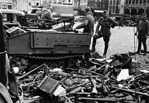 German soldiers pictured with a Vickers Utility Tractor (VUT) of the Belgian Army, and a pile of Belgian rifles and helmets the day after the Belgian surrender, 29 May 1940
