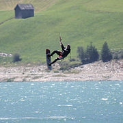 Ein Kitesurfer, mehrere Meter über dem Wasser (am Reschensee)