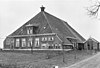 Grote stelphoeve met vier zesruitsvensters in voorgevel, melkkelder met twee kleine vensters en topschoorsteen met bord