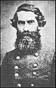 Black and white photo of a bearded man in a military uniform with two rows of buttons.