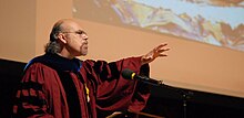 Дэвид Карраско выступает с речью на собрании Гарвардской школы богословия перед изображением Джорджа Йепеса «Товарный вагон».